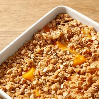Peach crisp recipe with fresh peaches in a baking dish fresh from the oven