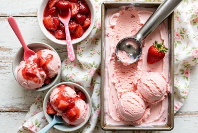 Homemade strawberry ice cream in a loaf tin, sliced and ready to serve